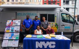 HPD Van & workers at a table