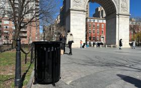 Black waste bin with the Washington Square Park Arch in the background